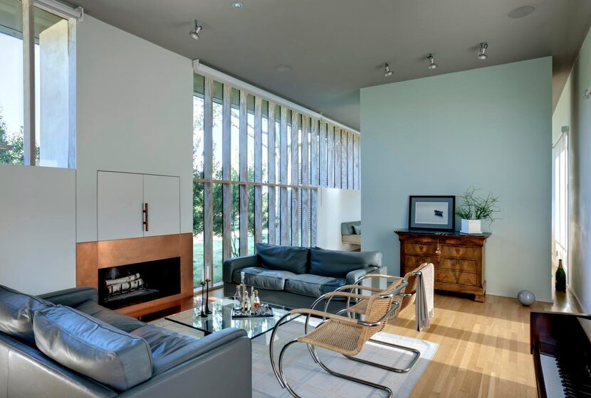 
Floor-to-ceiling windows bathe the living room in natural light, enhanced by the interior’s...