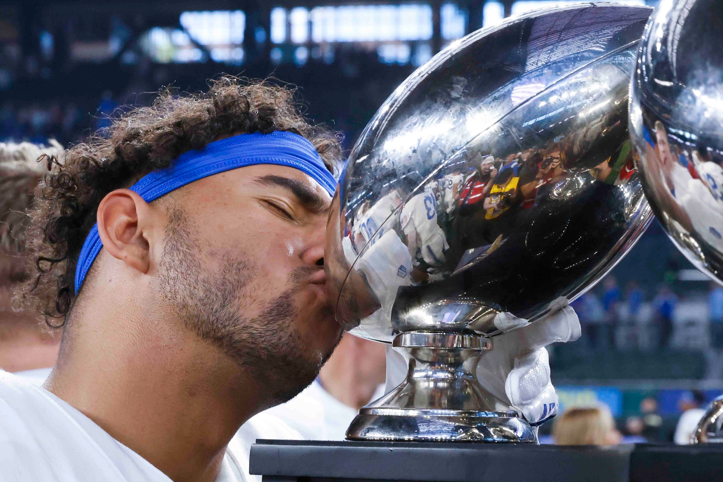 Air Force running back Aiden Calvert (22) kisses the trophy as his team celebrates their win...