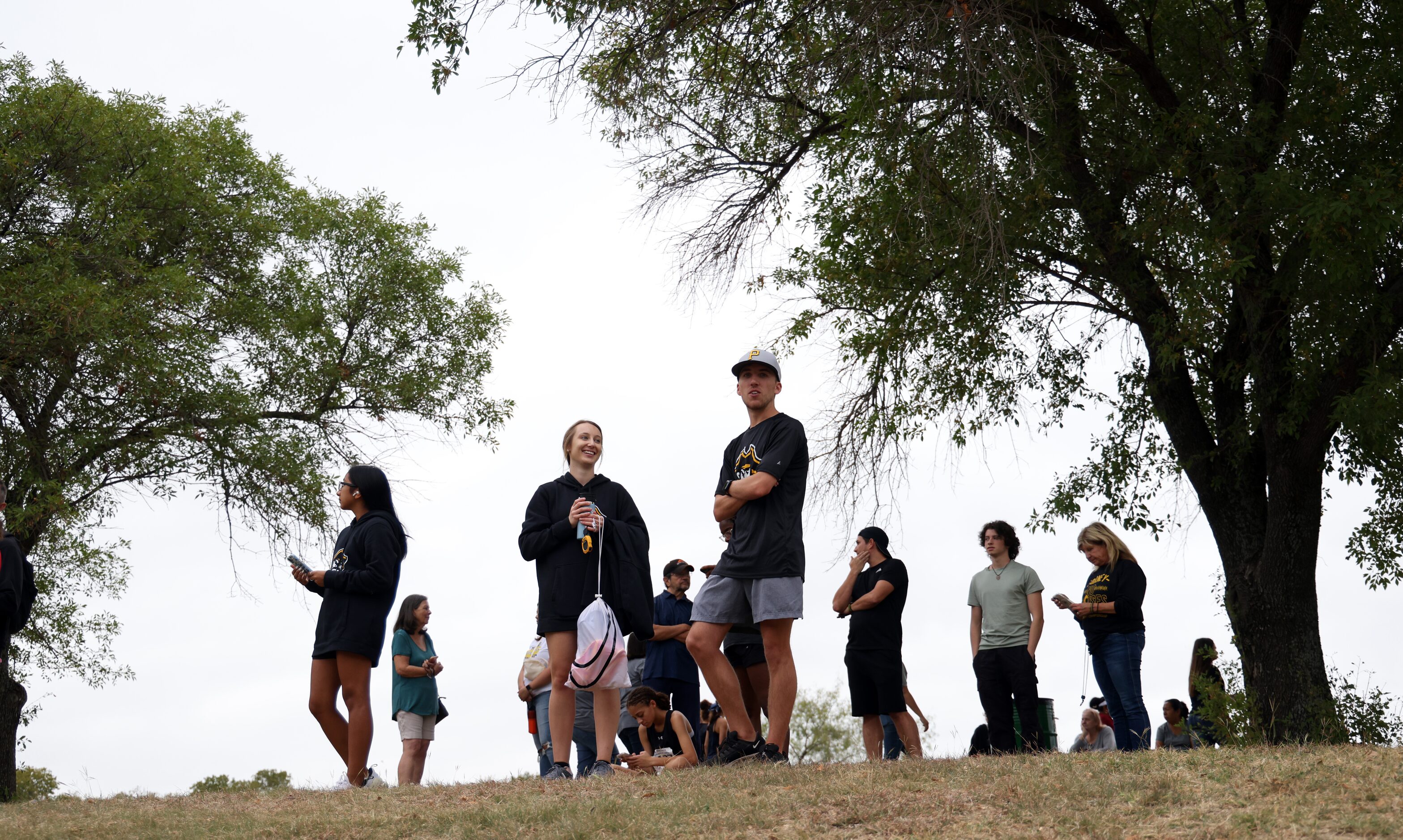 Cross Country race fans await runners to pass by along the trail during the Boys Class 5A...