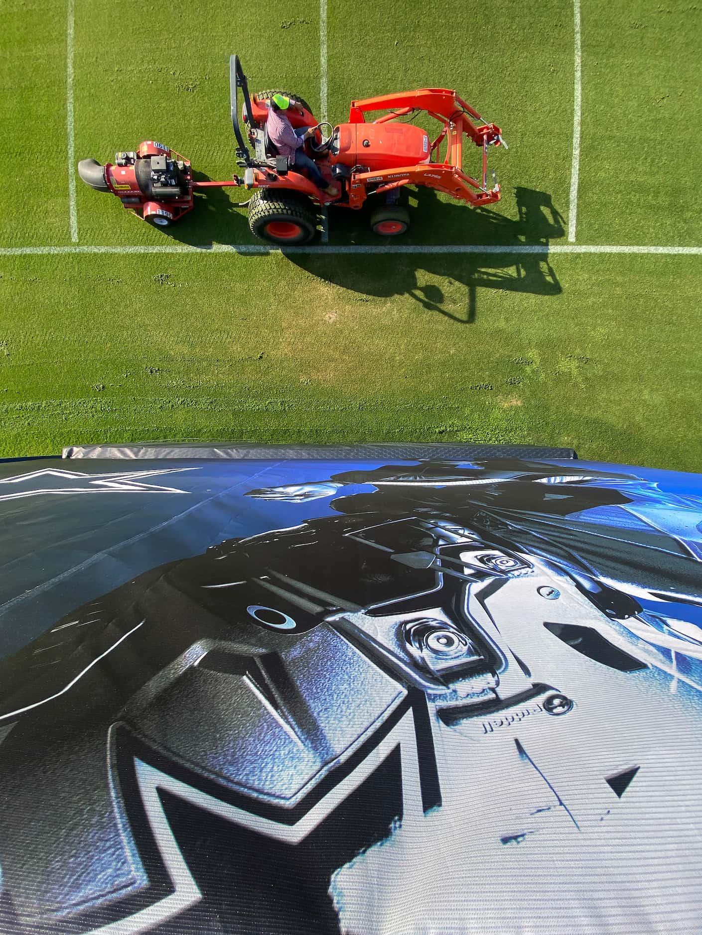 A grounds crewman blows freshly cut grass in preparation for the Dallas Cowboys first open...