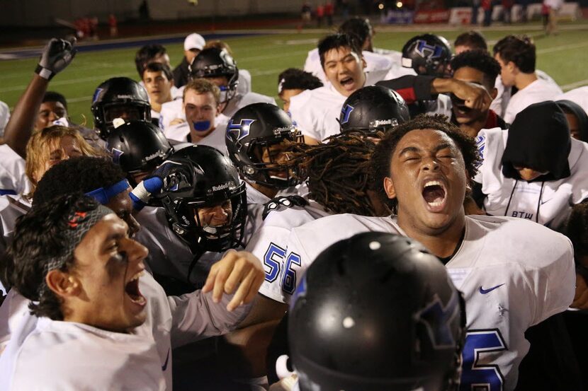 Hebron players celebrate after earning a spot in the playoffs following a high school...