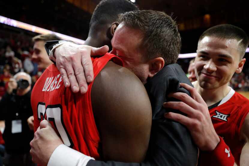 Texas Tech head coach Chris Beard, center, gets a hug from center Norense Odiase, left,...