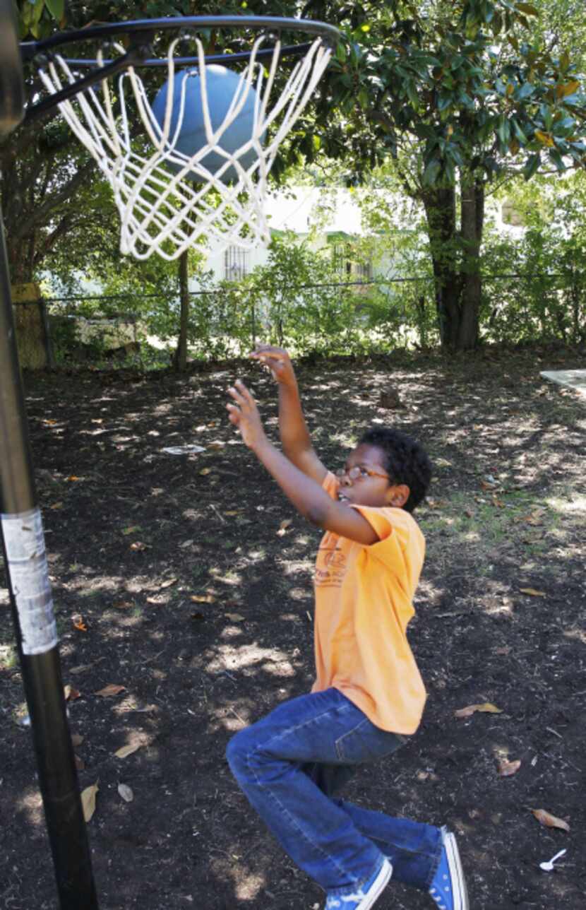 David Williams, 12, takes a five-minute break from his home schooling to shoot some hoops in...