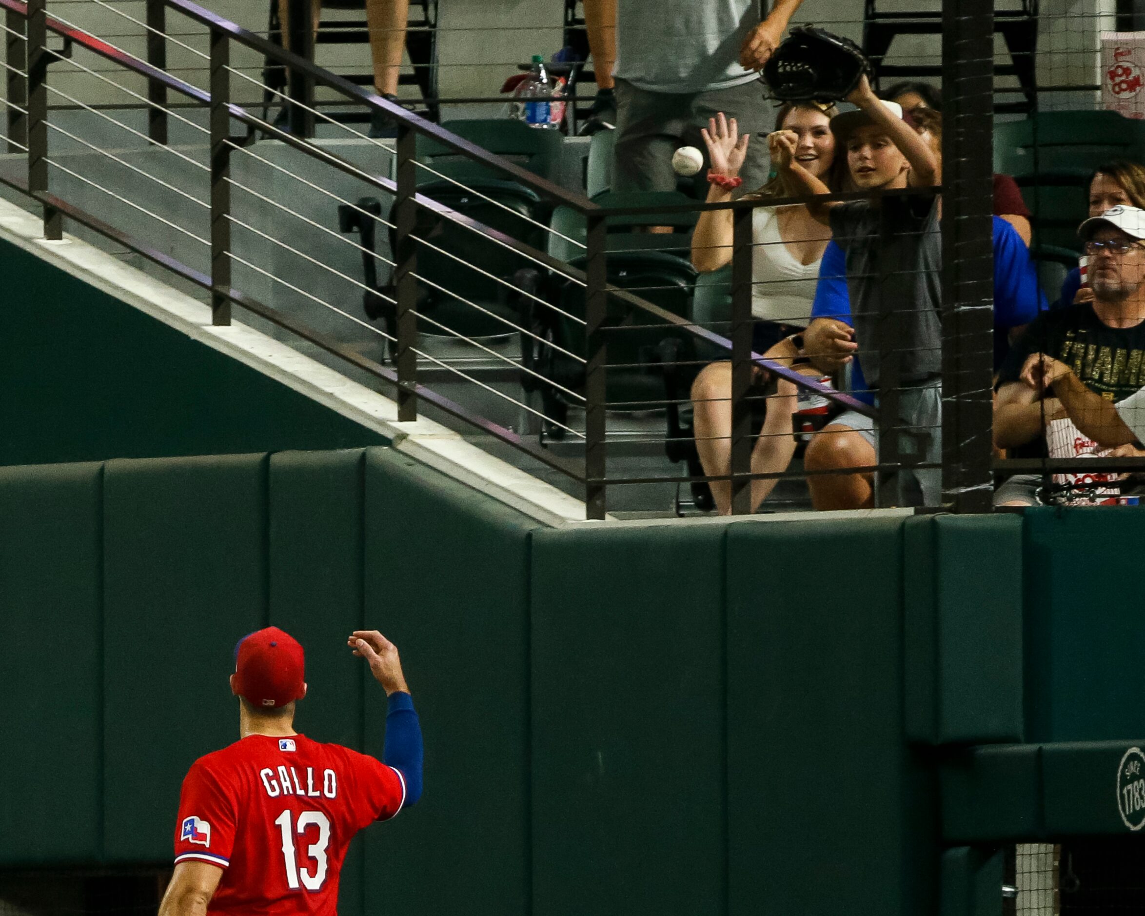 Texas Rangers right fielder Joey Gallo (13) tosses the ball to a young fan during the sixth...