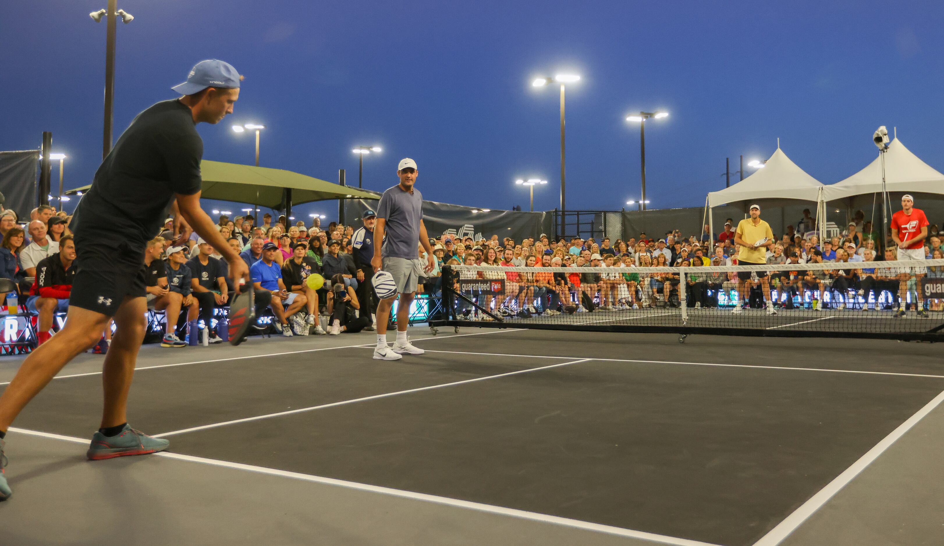 Jordan Spieth (right) serves the ball in a doubles match of pickleball in the Dick’s...