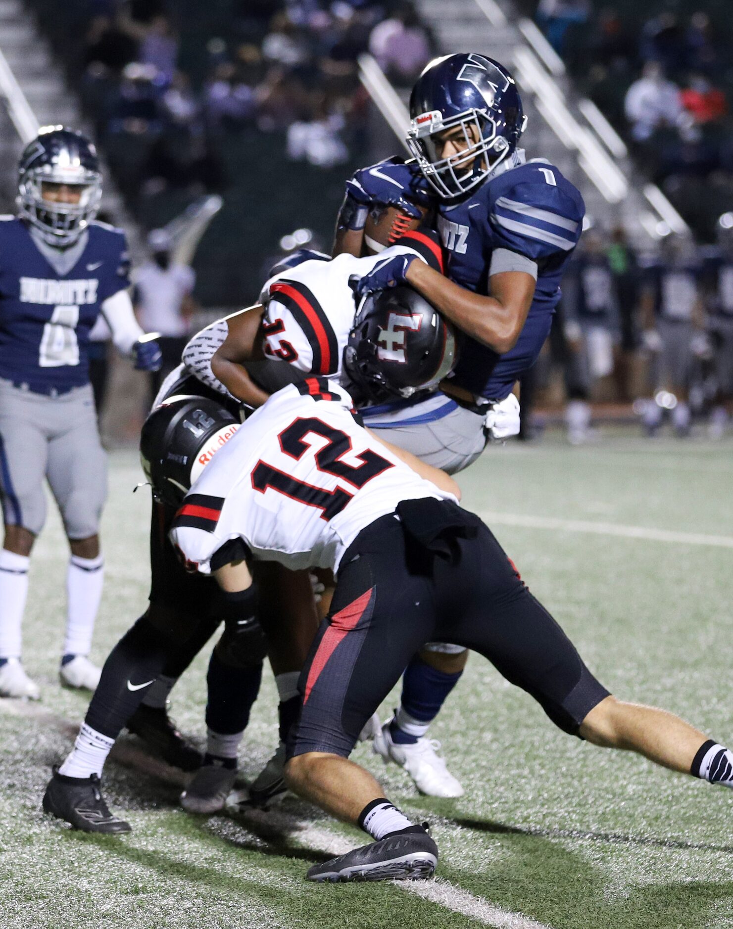 Lake Highlands defensive backs Carson Klein (12) and Chance Hardin (13) tackle Irving Nimitz...