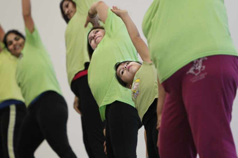 Melissa Salazar, 7, and others attend an exercise class at the Jubilee Park community...