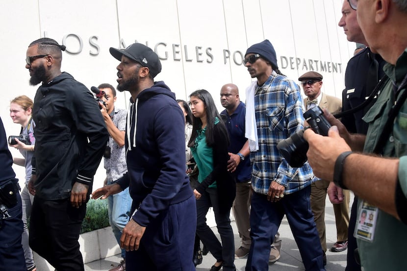 Rappers The Game (L) and Snoop Dogg (3/R) make their way into LAPD headquarters on July 8,...