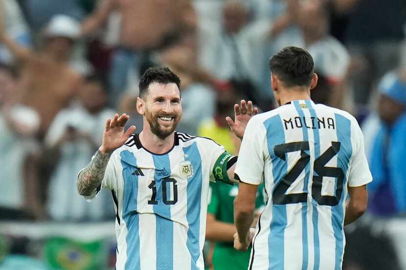 Argentina's Lionel Messi celebrates with Nahuel Molina after their team won the World Cup...