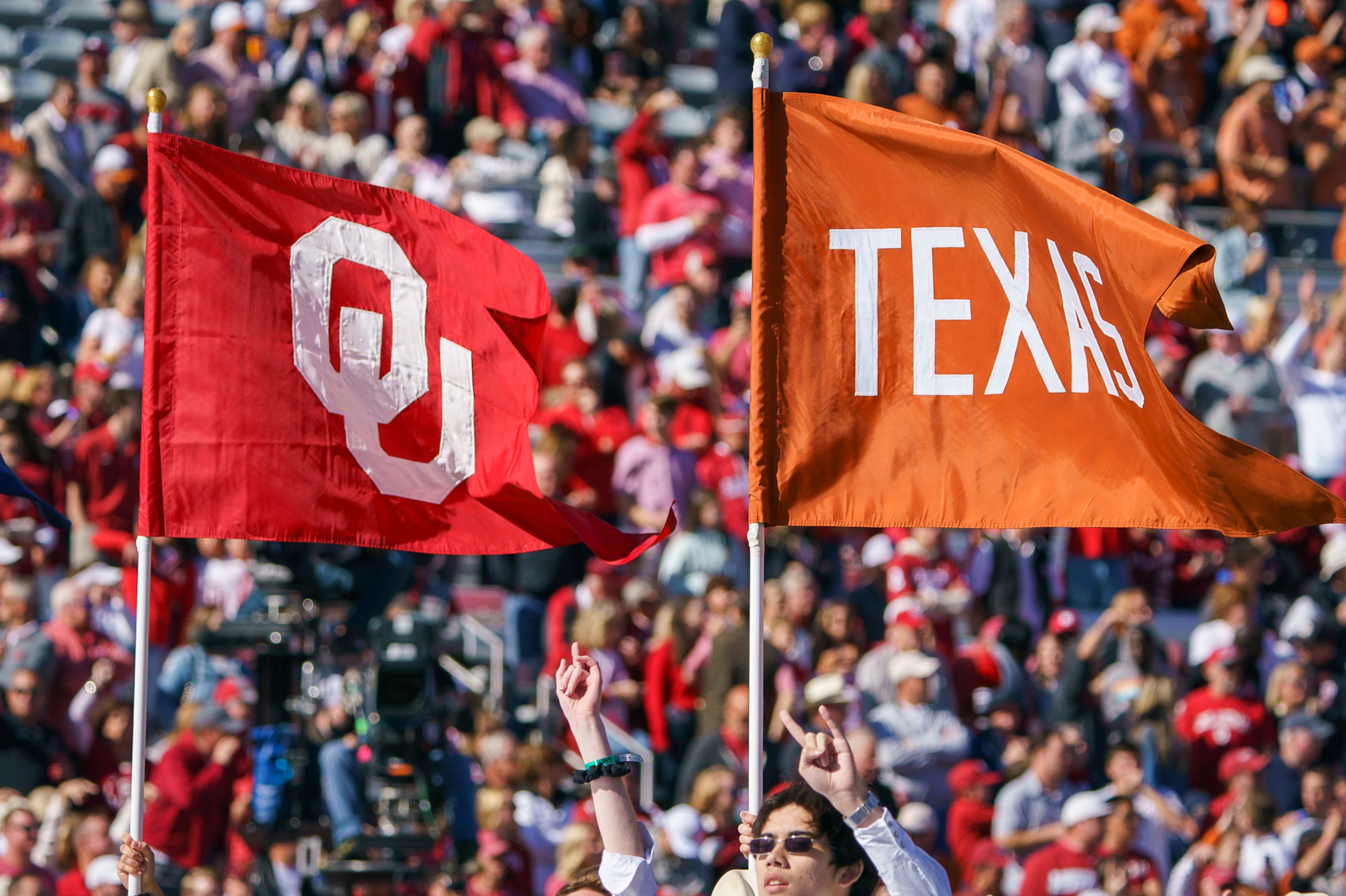 The Longhorn carries the flags of both schools before an NCAA football game between Texas...