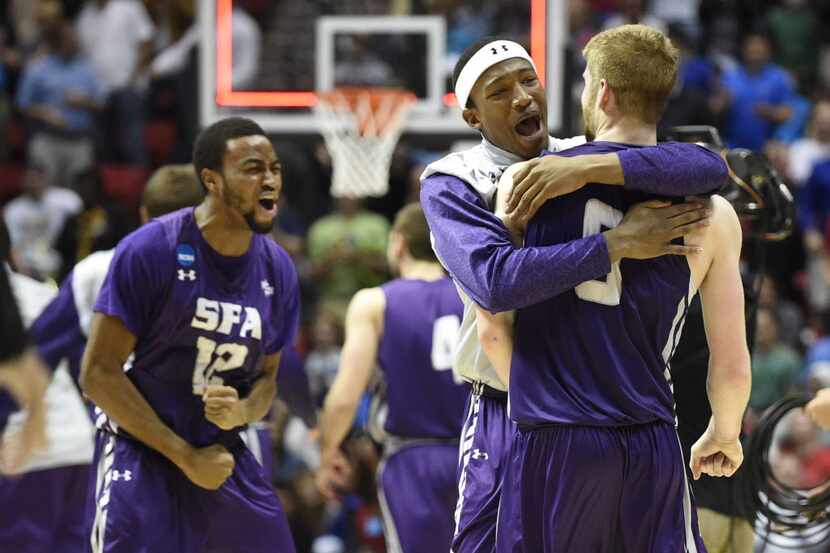 Stephen F. Austin forward Ben Brown-White, second from right, hugs teammate guard Thomas...