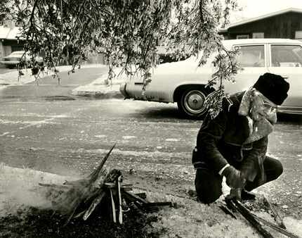 John Durmon tries to build a fire under a tree across the street from his home at 6527 Axton...