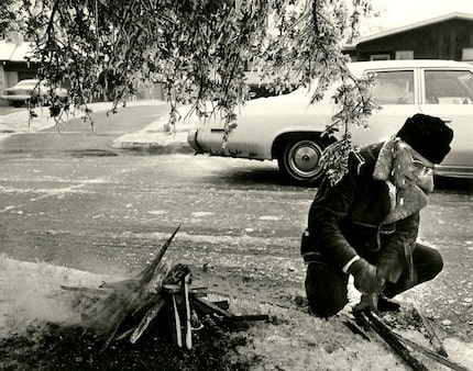 John Durmon tries to build a fire under a tree across the street from his home at 6527 Axton...