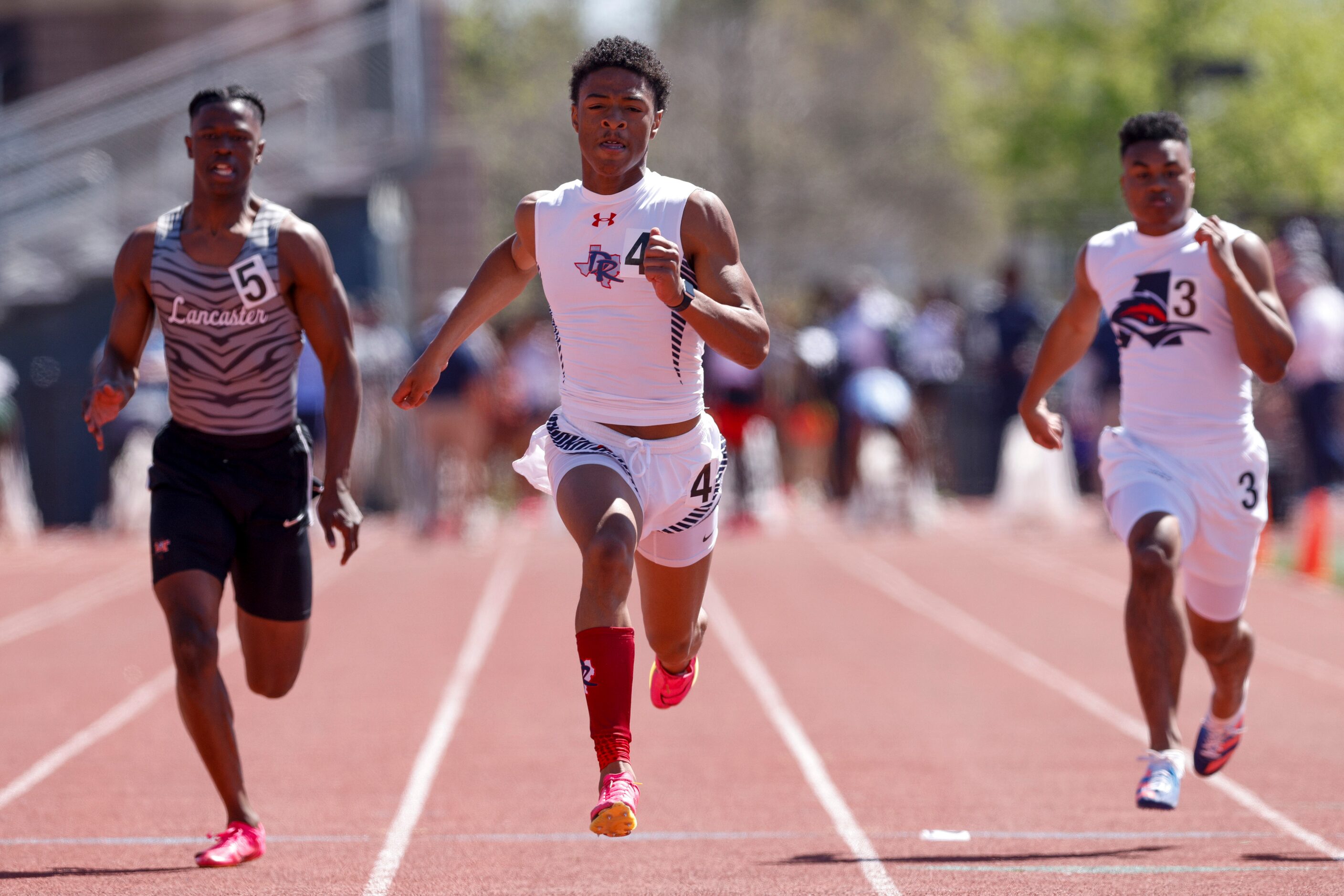 Denton Ryan’s Josiyah Taylor (center) wins the 5A 100 meter dash ahead of Lancaster’s Corian...