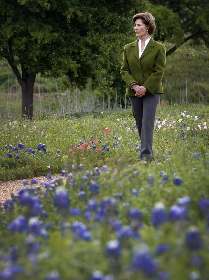 Former first lady Laura Bush walks by bluebonnets during a tour of the Native Texas Park at...