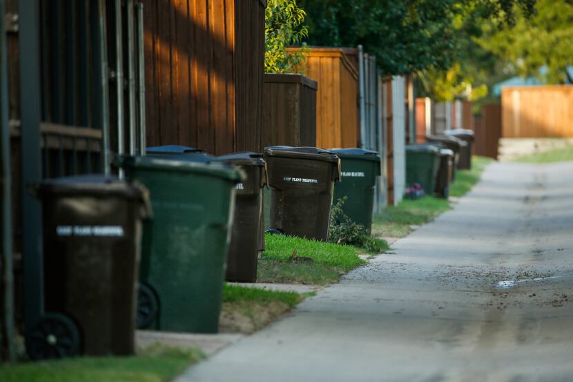 Trash cans line a residential alleyway on Thursday, July 16, 2020 in Plano, Texas. Grand...