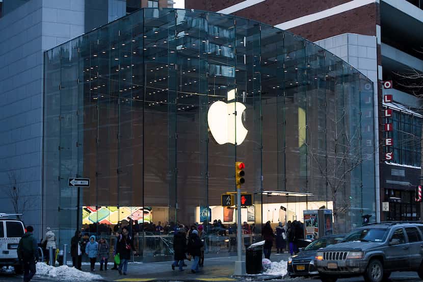 Pedestrians pass in front of an Apple Inc. store in New York, U.S., on Thursday, Jan. 23,...