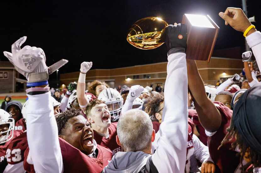 Lewisville players raise a Class 6A bi-district championship trophy after defeating Allen at...
