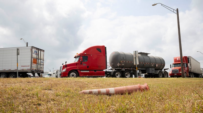 Trucks wait to be inspected by Texas State troopers at an inspection site close to the...