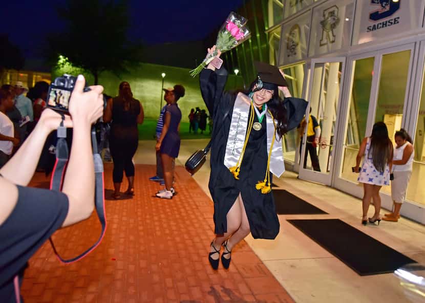 Salutatorian Han Bao Tran leaps in celebration for a photograph by a friend after the...