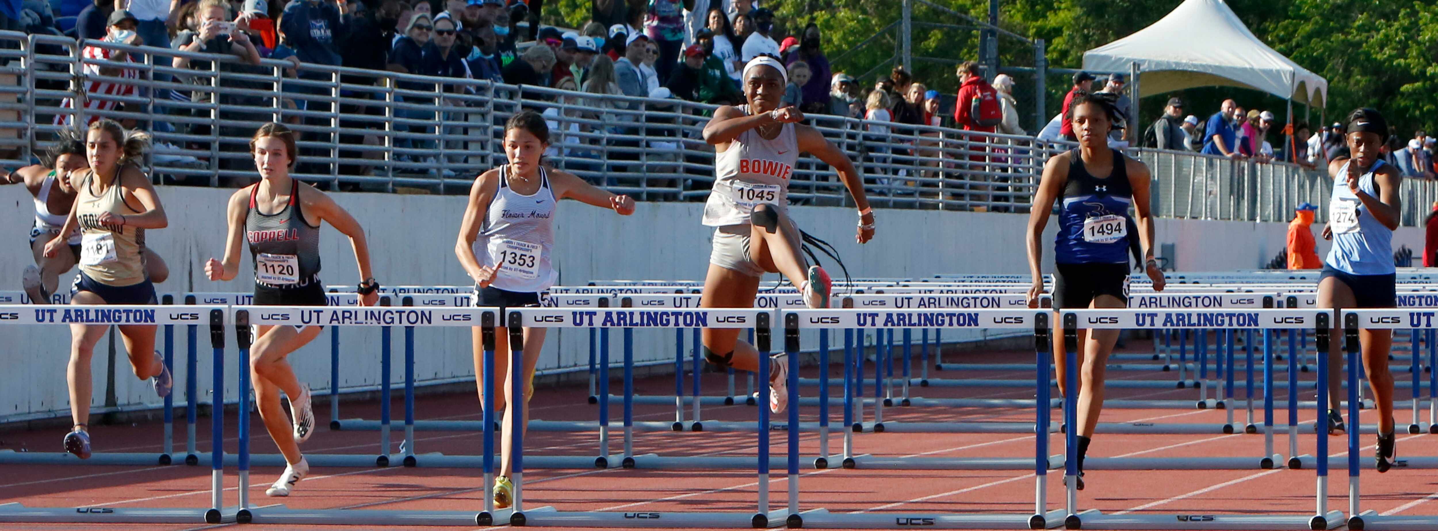 Arlington Bowie's Janet Nkwoparah, center, clears the final hurdle on her way to win the...