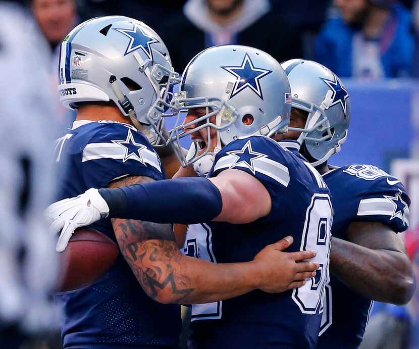 Dallas Cowboys quarterback Dak Prescott (4) congratulates tight end Jason Witten (82) on his...