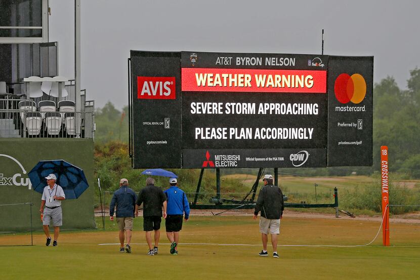 Fans cross the 18th fairway during a weather delay of the final round of AT&T Byron Nelson...