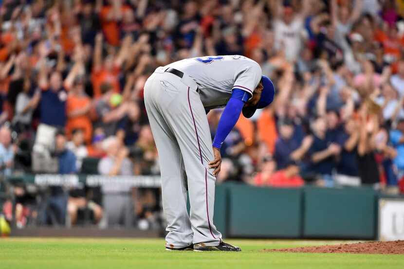 Texas Rangers relief pitcher Jeremy Jeffress reacts after giving up a solo home run to...