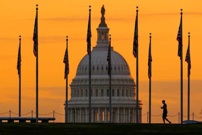 An early morning pedestrian is silhouetted against sunrise as he walks through the U.S....