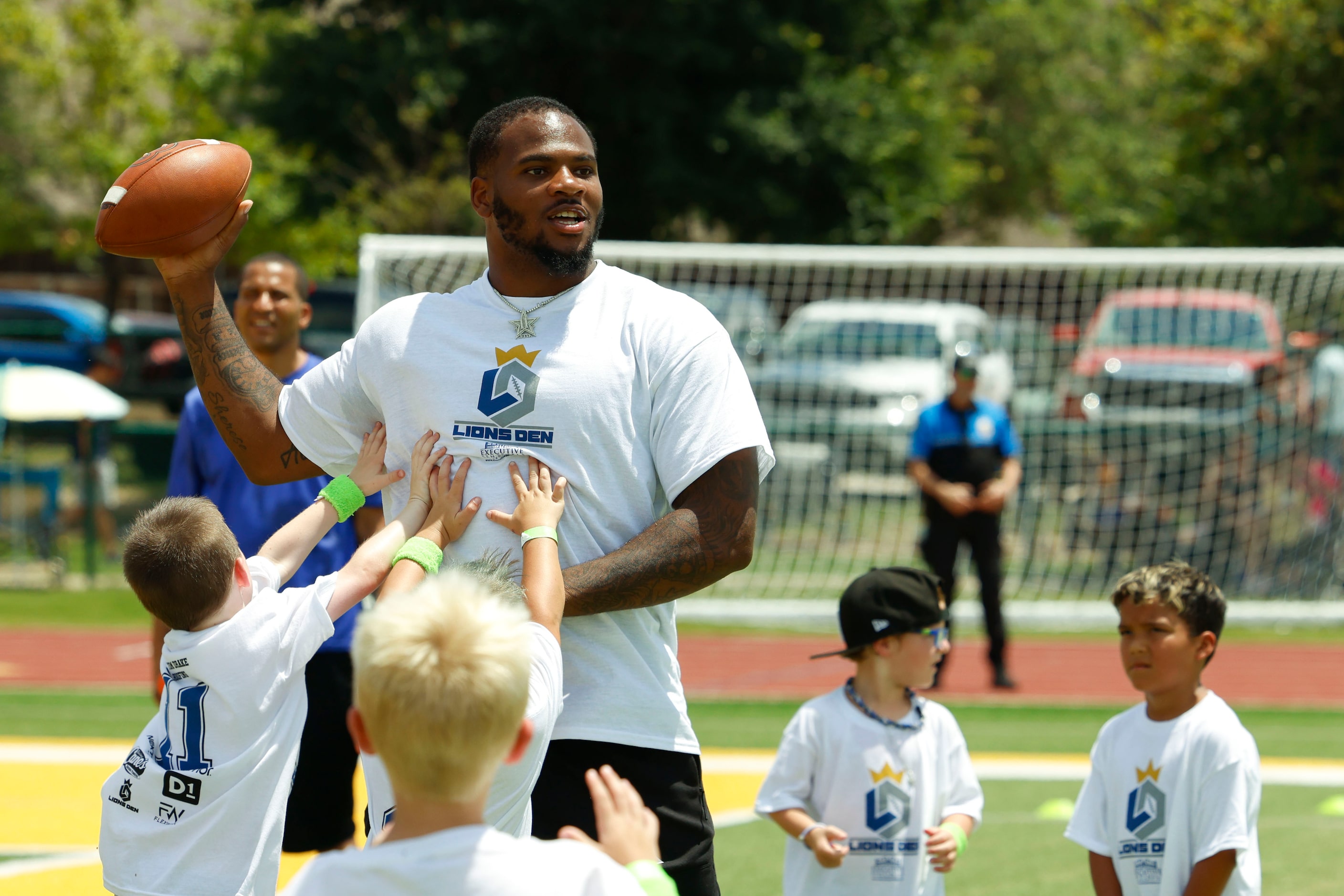 Dallas Cowboys linebacker Micah Parsons looks to throw the ball as he interacts with young...