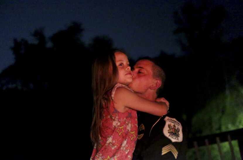 Sgt. Michael Hicks kisses his daughter, Stella, 7, on a break during his shift in Coventry,...