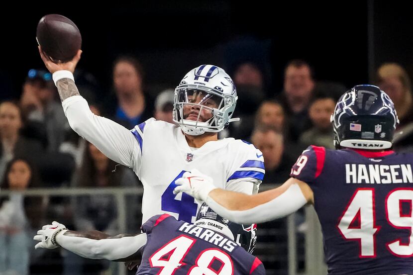 Dallas Cowboys quarterback Dak Prescott (4) throws a pas under pressure from Houston Texans...