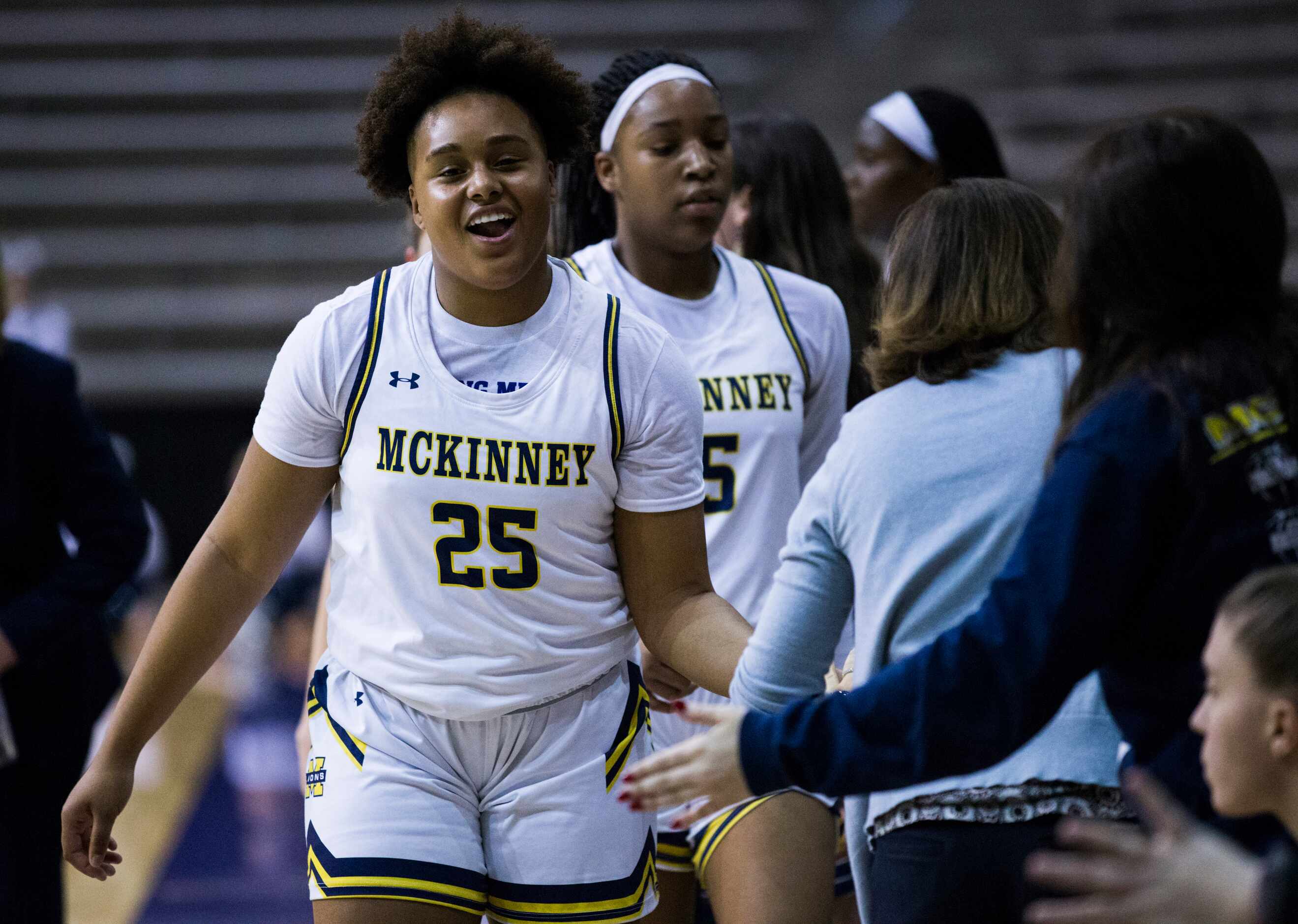 McKinney guard Nic Porter (25) smiles as she high-fives teammates at the end of a 66-53 win...