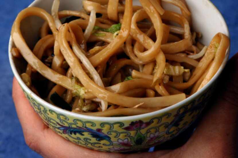Learn to make a long noodle dish that's a standard part of the Chinese New Year feast, in a...
