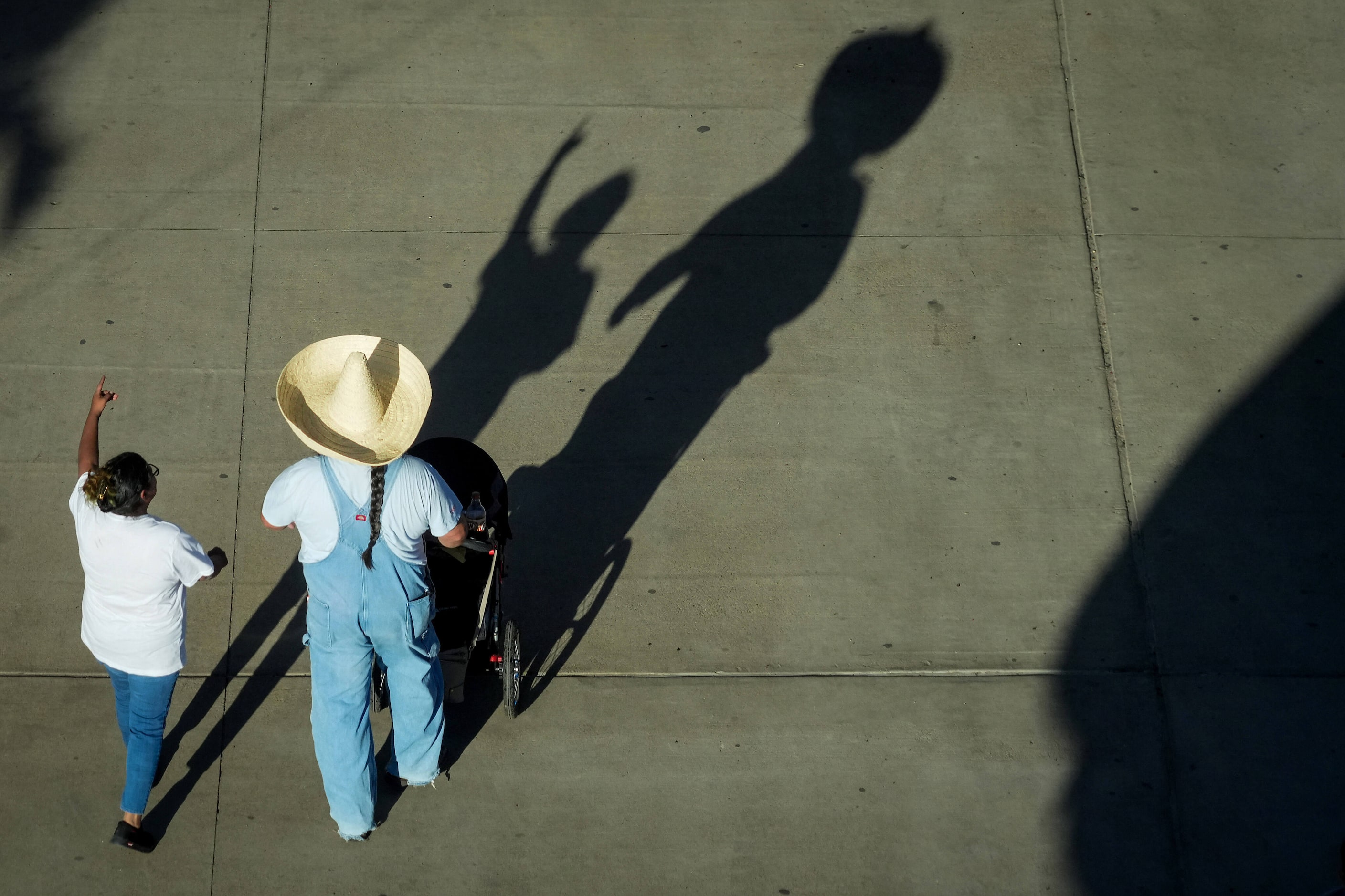 Fairgoers long shadow across the midway at the State Fair of Texas on Sunday, Sept. 29,...