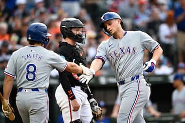 Texas Rangers' Corey Seager, right, is greeted by Josh Smith (8) after hitting a solo home...