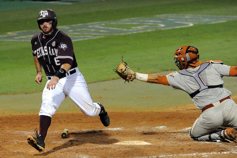 Texas A&M's Troy Stein, left, scores a run past Texas catcher Tres Barrera during the fourth...