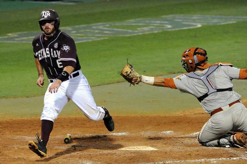 Texas A&M's Troy Stein, left, scores a run past Texas catcher Tres Barrera during the fourth...