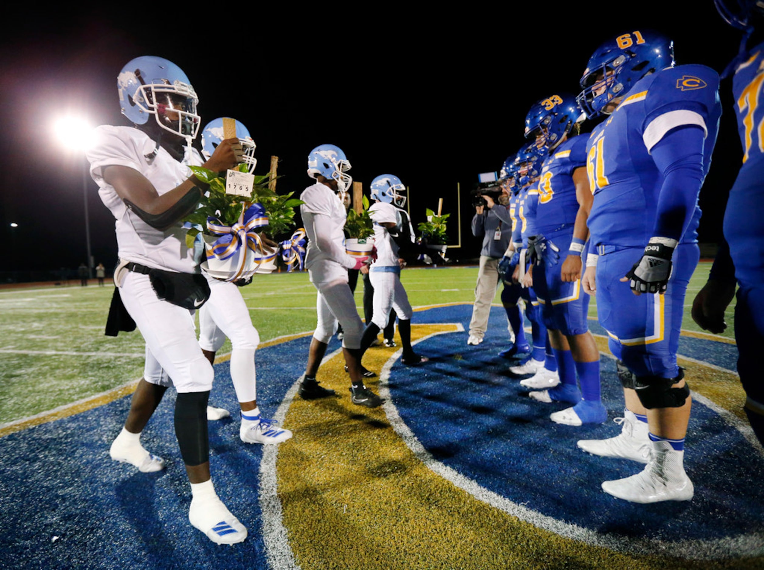 Dallas Roosevelt football captains gave plants to Community High football captains during...