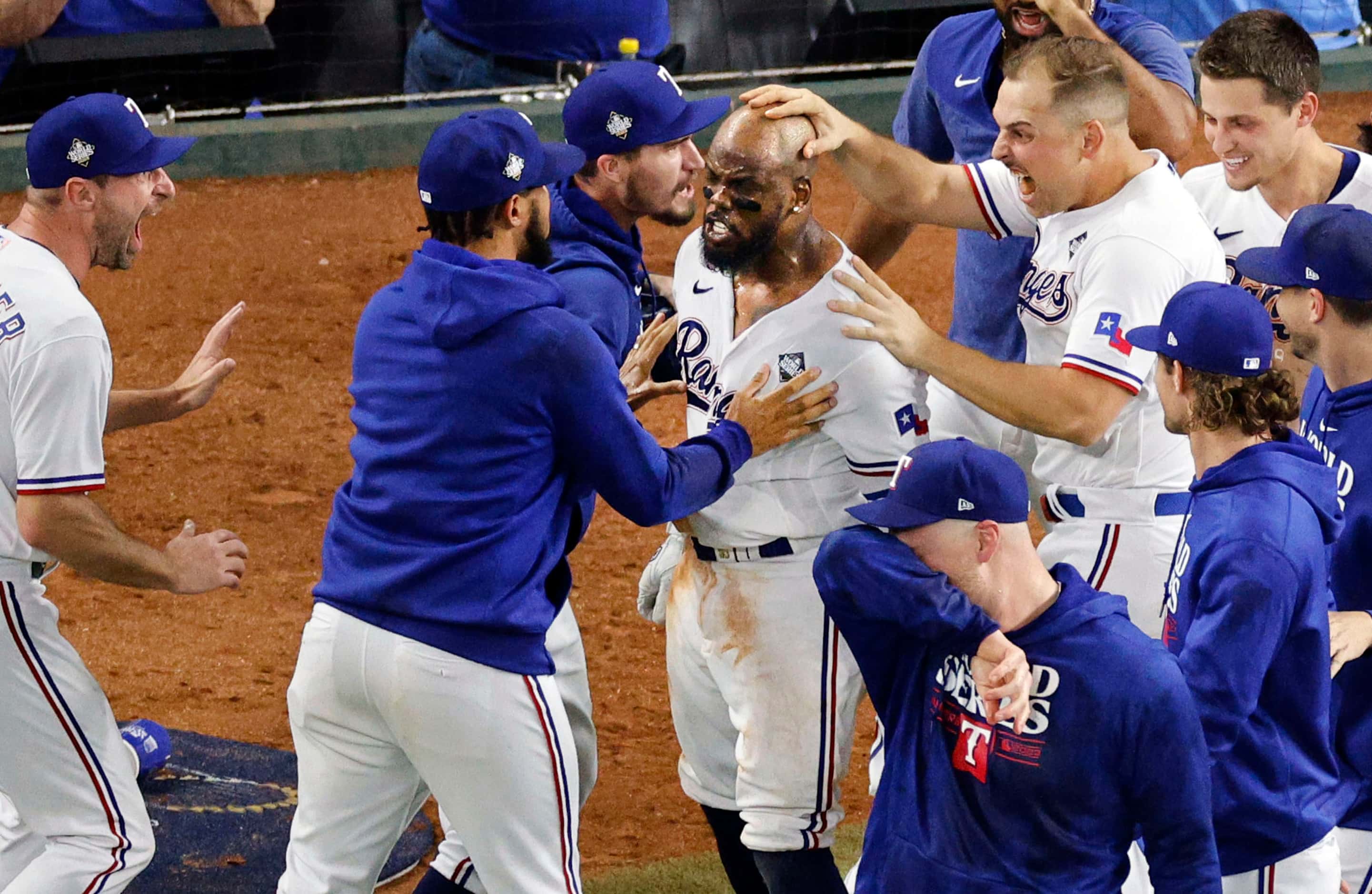 Texas Rangers right fielder Adolis Garcia (53), center, celebrates with his teammates after...