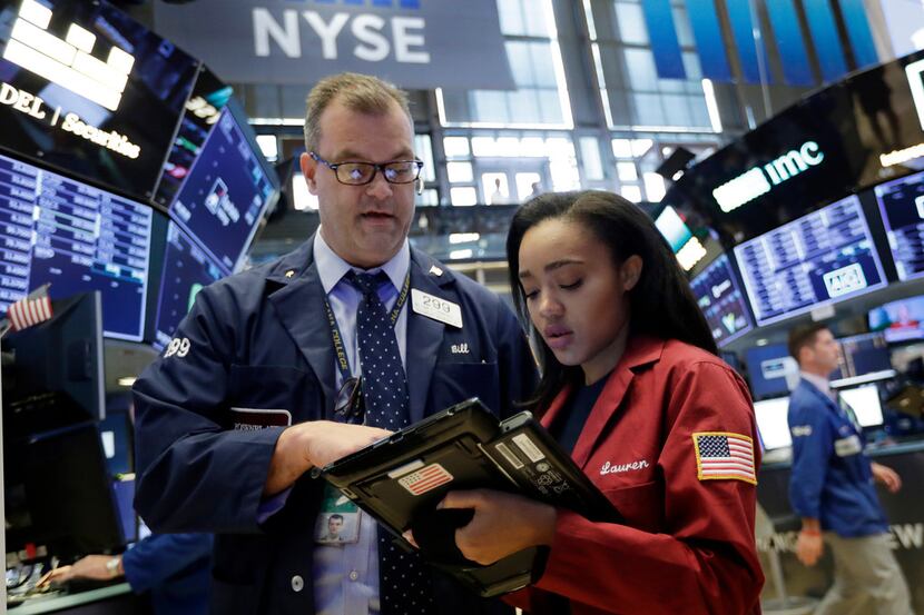 Traders William Lawrence and Lauren Simmons work on the floor of the New York Stock...