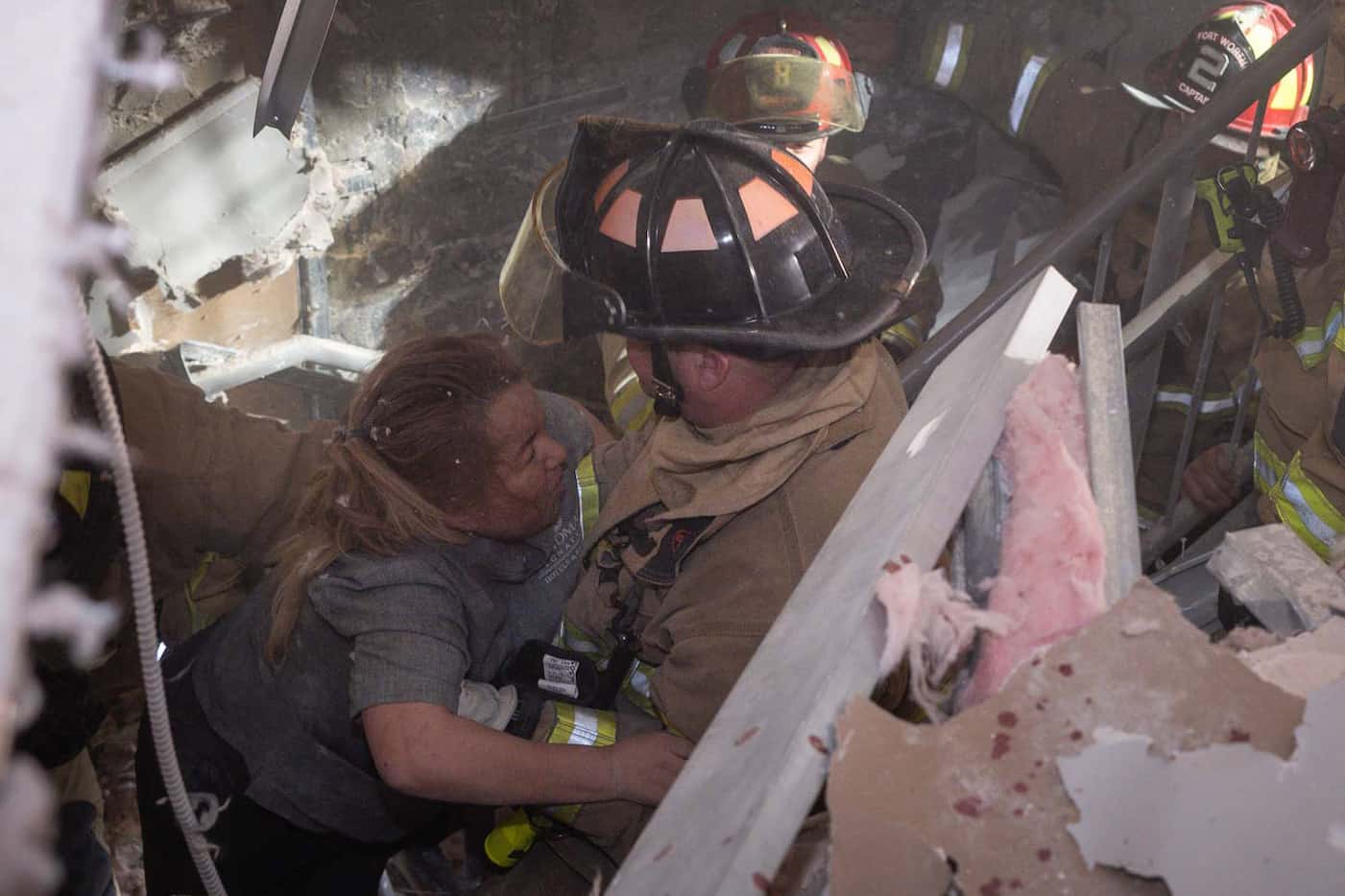 Fort Worth firefighters rescue a woman following an explosion at the Sandman Signature Hotel...