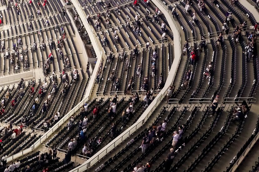 A socially distanced crowd, separated into what team officials described as "pods," stands...