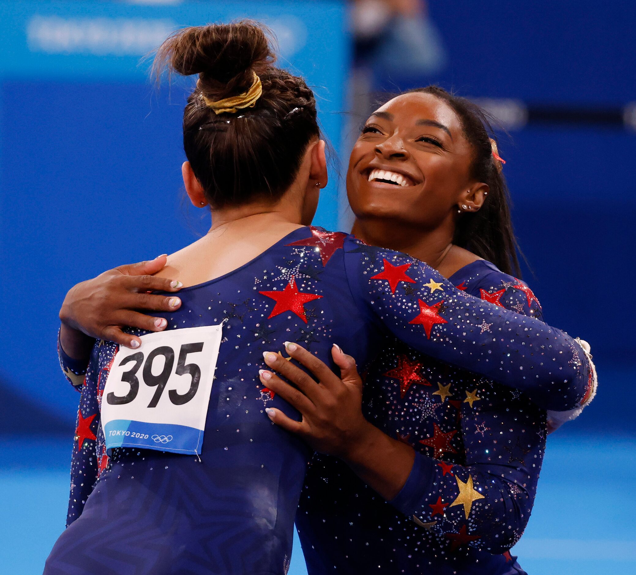 USA’s Sunisa Lee hugs Simone Biles after she competed on the uneven bars in a women’s...