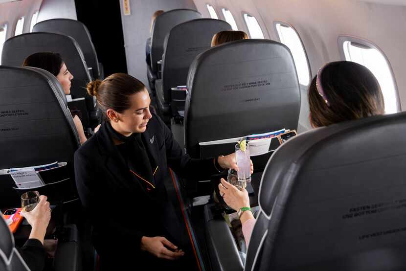 Aero flight attendant Angie Gutierrez brings a drink out during a media preview flight over...