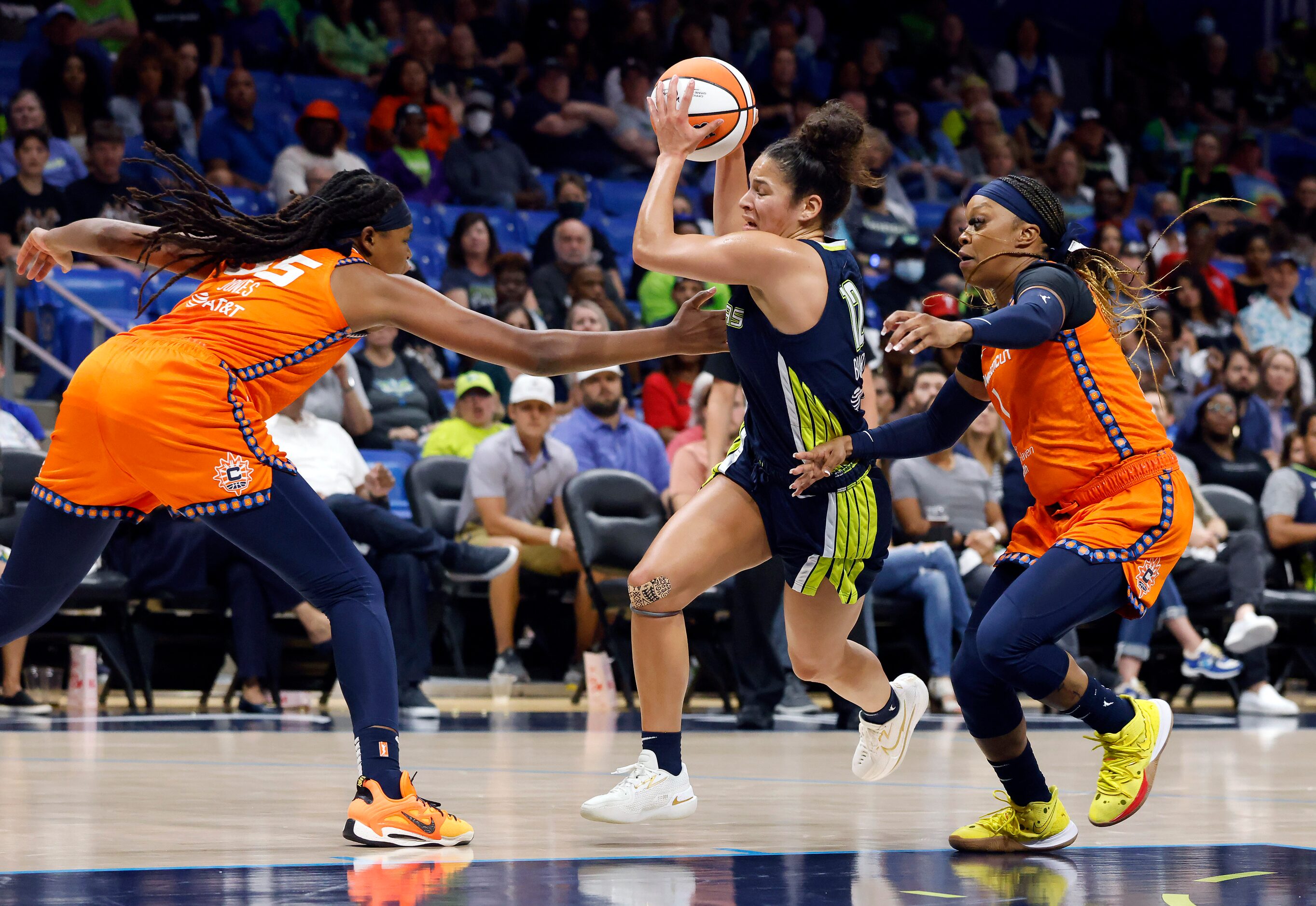 Dallas Wings guard Veronica Burton (12) drives between Connecticut Sun forward Jonquel Jones...