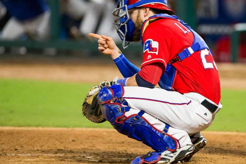 Texas Rangers catcher Jonathan Lucroy points to starting pitcher Yu Darvish during the sixth...