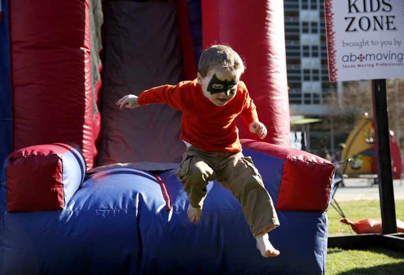 Dillon Bryant, 3, jumps off the slide at the 4th Annual Mudbug Bash in Main Street Garden in...