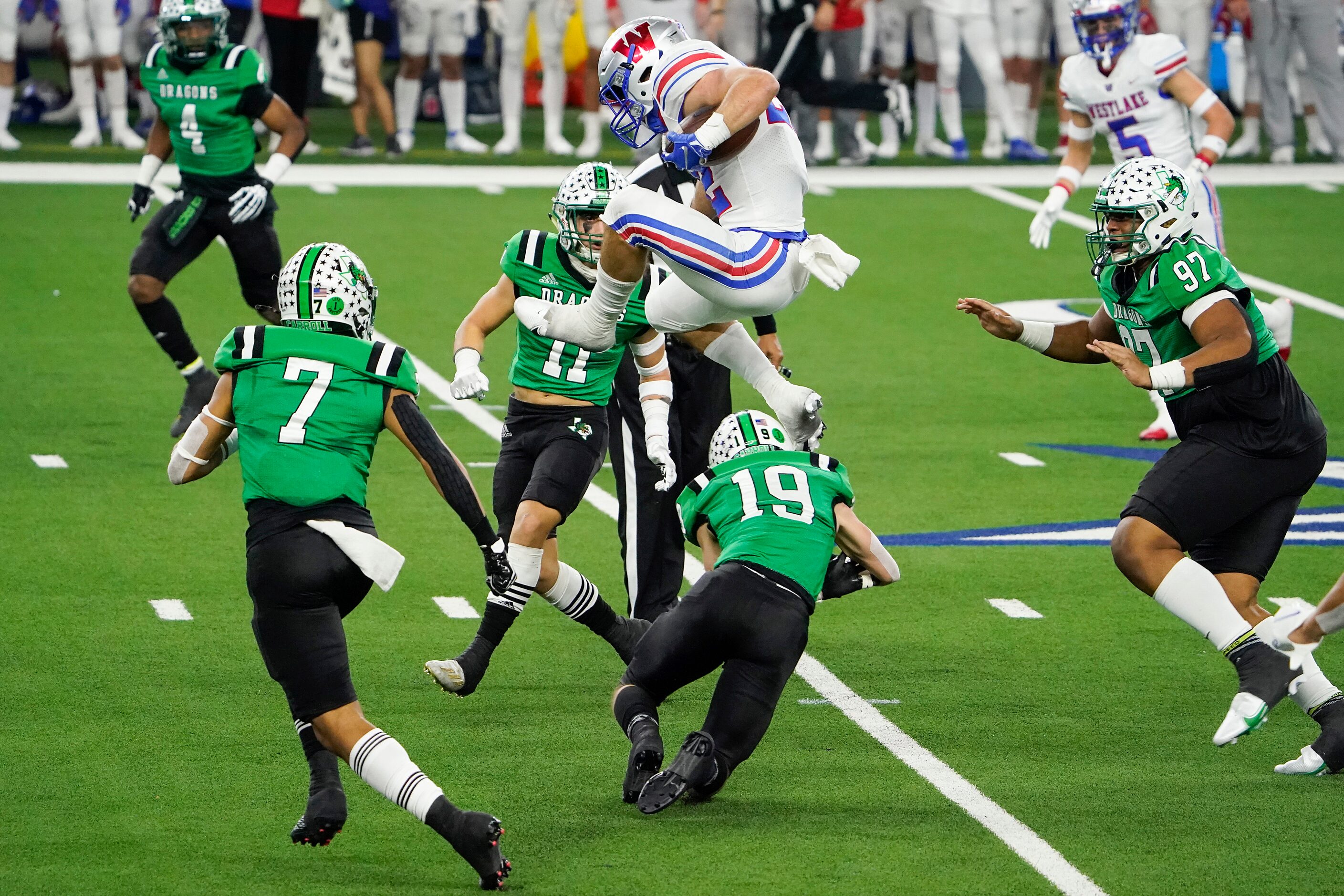 Austin Westlake running back Grey Nakfoor (22) hurdles Southlake Carroll defensive back...