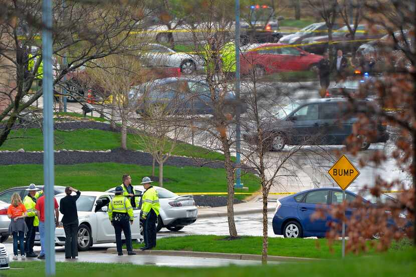 Law-enforcement authorities stand near the location of a shooting Sunday at the Jewish...